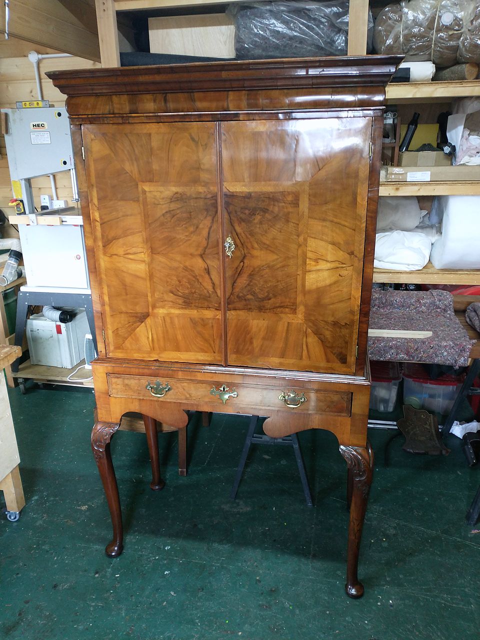Cabinet on stand with figured veneer doors, crossbanding, brass handles and cabriole legs, after polishing