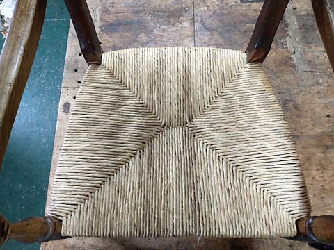 Close-up of a freshly woven rush seat showing the four-way pattern